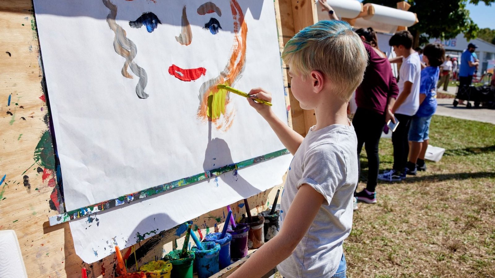 a boy drawing an image of a girl at a coconut groove arts festival 